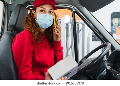 A Female Delivery Driver With A Medical Mask Calling A Person About Their Package