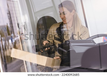 Similar – Image, Stock Photo Female delivery driver using barcode scanner checking pacel in a van in the city