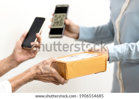 Female delivery worker deliver parcel box,old people receive ordered goods from online shopping,payment purchase on mobile phone scan QR code pay from home,lifestyle,learning technology in the elderly