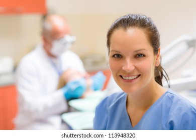 Female Dental Assistant Smiling At Stomatology Office Dentist With Patient