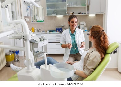 Female Dentist In Dental Office Talking With Female Patient And Preparing For Treatment.