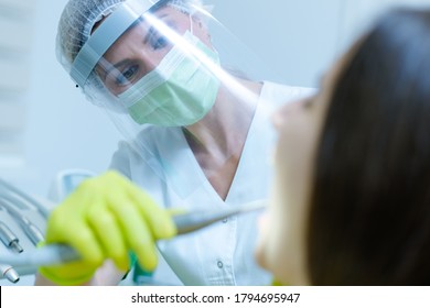 Female Dentist With Face Mask And Visor As Coronavirus Safety Precaution Checkup Dental Health Of Young Woman