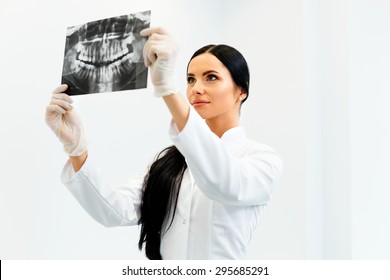 Female Dentist Looking At Dental Xray In Clinic