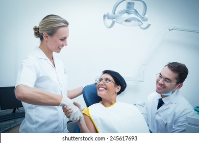 Female Dentist Shaking Hands With Woman In The Dentists Chair