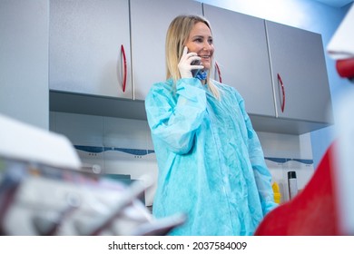 Female Dentist Talking On The Phone At Dental Office.