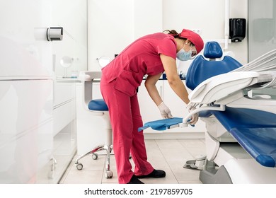 Female Dentist Working In Modern Dental Clinic And Wearing Face Mask. She Is Also Wearing Dental Safety Glasses.