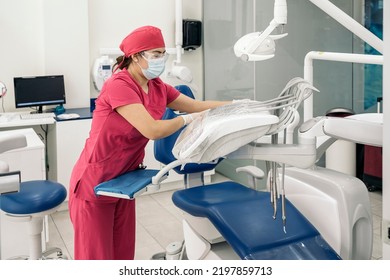 Female Dentist Working In Modern Dental Clinic And Wearing Face Mask. She Is Also Wearing Dental Safety Glasses.