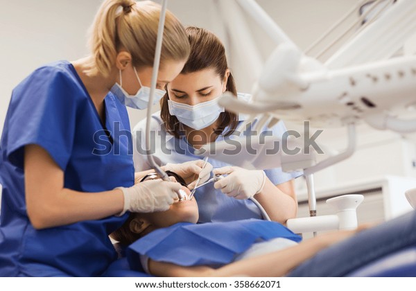 female dentists\
treating patient girl\
teeth