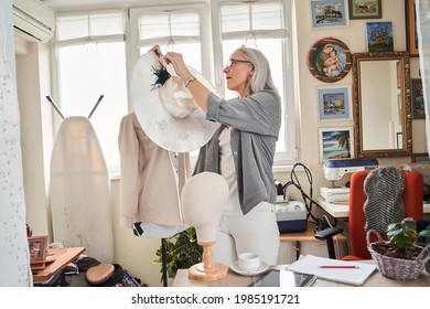 Female designed created handmade hat, while standing near the mannequin - Powered by Shutterstock