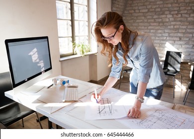 Female designer in office working on architects project - Shutterstock ID 645444466