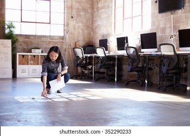 Female Designer Planning Layout On Floor Of Modern Office