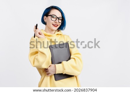 A female designer in yellow hoody holding a graphic tablet. The background is white