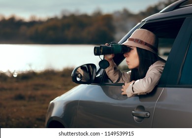 Female Detective Spying With Binocular From A Car. Secret Agent Private Investigator Looking For Evidence In Infidelity Case
