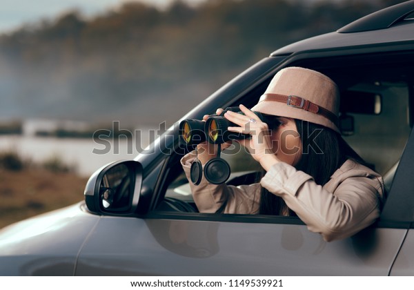 Female Detective Spying with Binocular from a Car.\
Secret agent private investigator looking for evidence in\
infidelity case\
