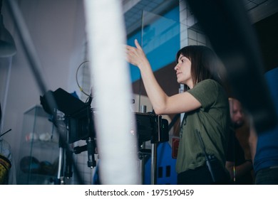 Female Director Of Photography With A Camera On A Movie Set. Professional Videographer On The Set Of A Movie, Commercial Or TV Series. Filming Indoors, Studio