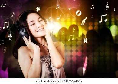 Female Disc Jockey Playing Music While Dancing With Crowd People At Nightclub In Blurred Sparkling Light Background