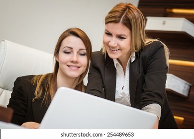 Female Discusses Work On Computer With Assistant In An Office Setting.