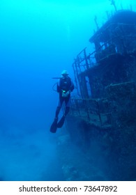 Female Diver floating vertically alongside Halliburton shipwreck, Utila, Honduras