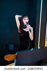 A Female DJ In A Black Slip-dress Is Playing Songs.