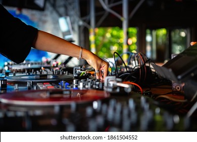 Female Dj Mixes Musical Tracks On Party In Bar.Professional Disc Jockey Girl Playing Music On Hip Hop Entertainment Event In Club.Musician Regulates Volume With Sound Mixer Controller On Stage