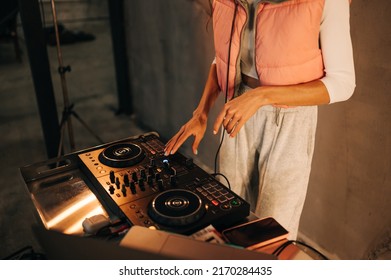 Female DJ playing at a party, close up photo of hands using controller on laptop. The work of a DJ.