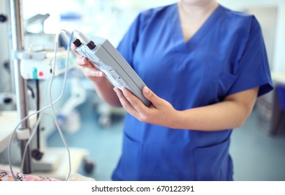 Female doctor adjust electronic medical device.