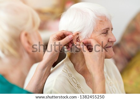 Similar – Image, Stock Photo Woman applying hearing aid to ear
