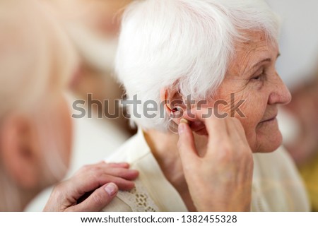 Similar – Image, Stock Photo Woman applying hearing aid to ear