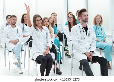 female doctor asks a question to the lecturer during the seminar - Powered by Shutterstock