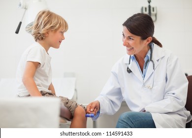 Female Doctor Auscultating A Child In Examination Room, Healthcare Workers In The Coronavirus Covid19 Pandemic