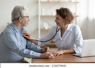 Female Doctor Cardiologist Examining Senior Male Cardiac Patient Listening Checking Heartbeat Using Stethoscope At Checkup Hospital Visit. Old People Medicare, Elderly Healthcare Cardiology Concept.