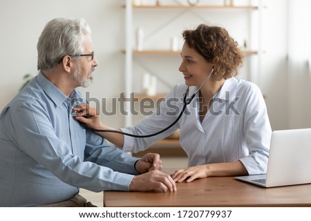 Female doctor cardiologist examining senior male cardiac patient listening checking heartbeat using stethoscope at checkup hospital visit. Old people medicare, elderly healthcare cardiology concept.