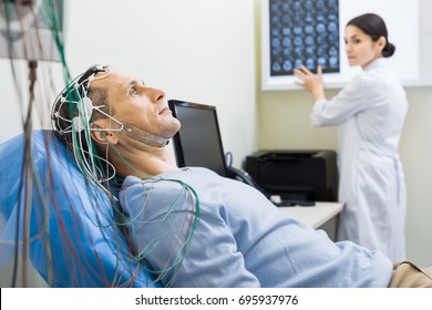 Female doctor carrying out electroencephalography of man