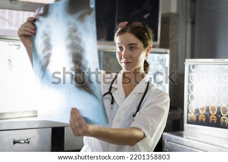 Female doctor checking anatomy and physiology x-ray film of patient in the hospital