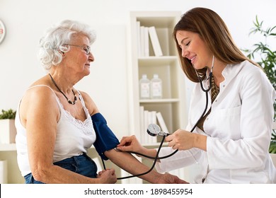 Female Doctor Checking Blood Pressure Of Senior Woman In Ambulance