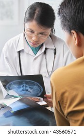 Female Doctor Checking Patient Xray While Writing Notes