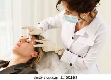 Female Doctor And Client During Filler Injections In Aesthetic Medical Clinic