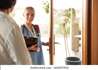 Female doctor with clipboard during home visit while entering house - Powered by Shutterstock