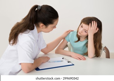 Female Doctor Comforting Depressed Patient Sitting At Table - Powered by Shutterstock