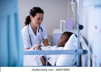 Female doctor consoling patient during visit in ward at hospital - Powered by Shutterstock