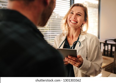 Female Doctor Consulting A Patient In Clinic. Smiling Female Medical Professional Interacting With A Patient.