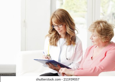 Female doctor consulting with senior patient at private clinic. 