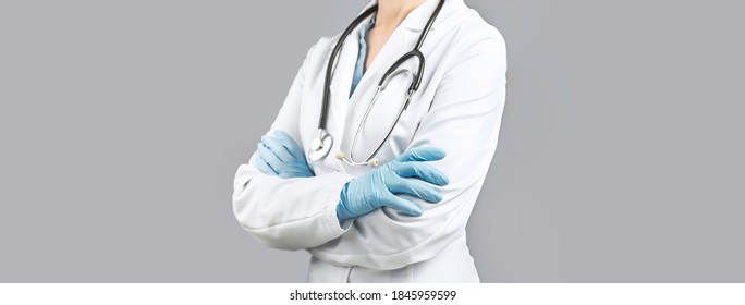 Female Doctor With Crossed Hands Over Grey Background. Impersonal No Face. Medical Banner. Copy Space. Book Appointment Or Checkup Time Reminder. Doctors Advice