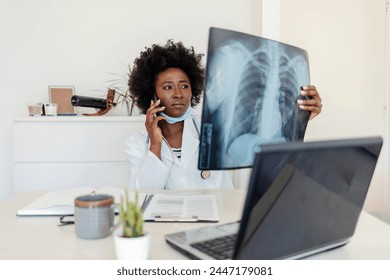 Female doctor diagnosing patients health on asthma, lung disease, COVID-19, coronavirus or bone cancer illness with radiological chest x-ray film for medical healthcare hospital service. - Powered by Shutterstock