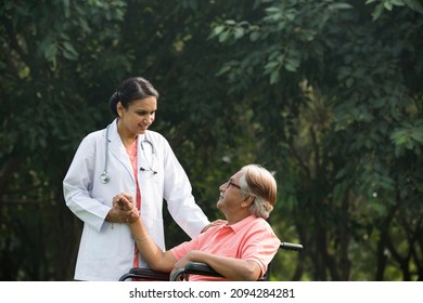 Female doctor discussing with senior man in wheelchair at park - Powered by Shutterstock