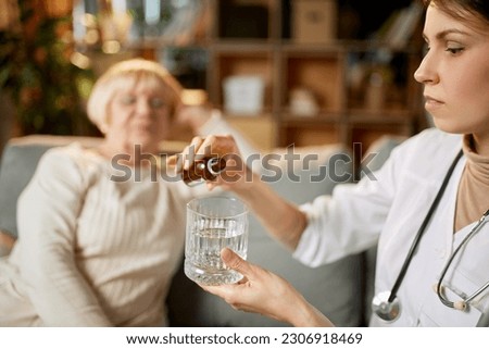 Female doctor giving medication to elderly patient