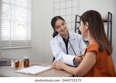 Female doctor and elderly female patient who are undergoing their annual health check-up at the clinic, using a stethoscope to examine patients - Powered by Shutterstock