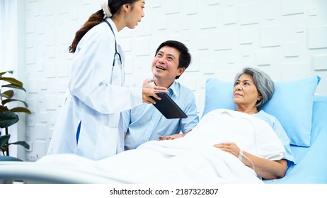 Female Doctor Enters Patient Room To Tell A Better Outcome Of Treatment While Elderly Patients And Her Son Was Having Fun Chatting. Female Patient And A Son Greet The Doctor With Bright Smiles.