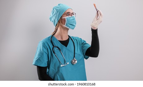 Female Doctor Examines A Blood Sample For The Corona Virus - Studio Photography