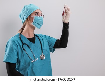 Female Doctor Examines A Blood Sample For The Corona Virus - Studio Photography